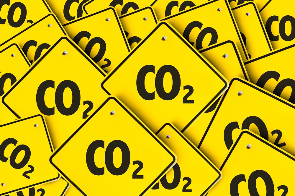 Ein Stapel gelber Warnschilder mit der Aufschrift „CO₂“ in großen schwarzen Buchstaben. Die Schilder symbolisieren die Warnung vor Kohlendioxid und dessen Auswirkungen auf die Umwelt.